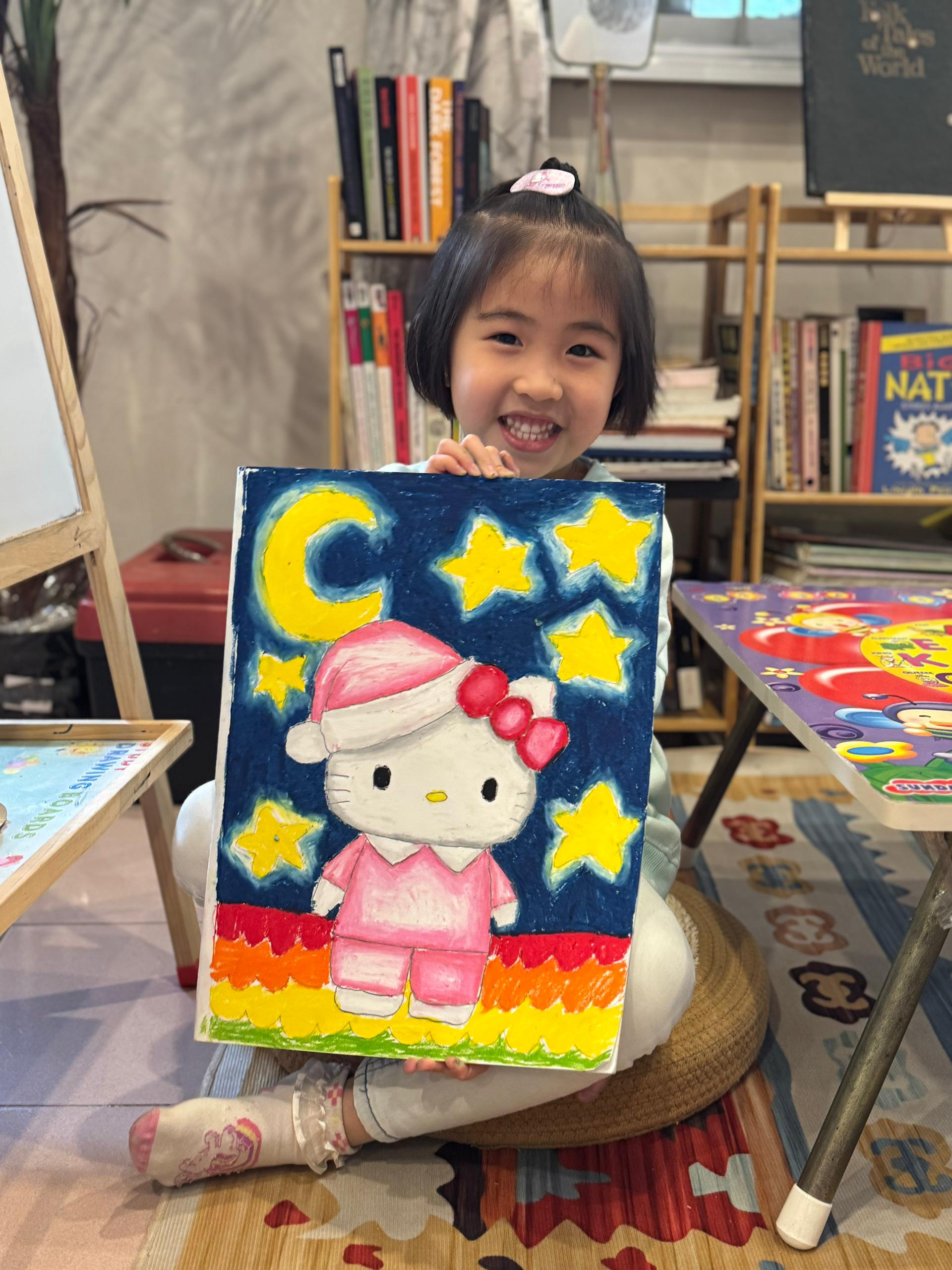 Student holding character-themed painting
