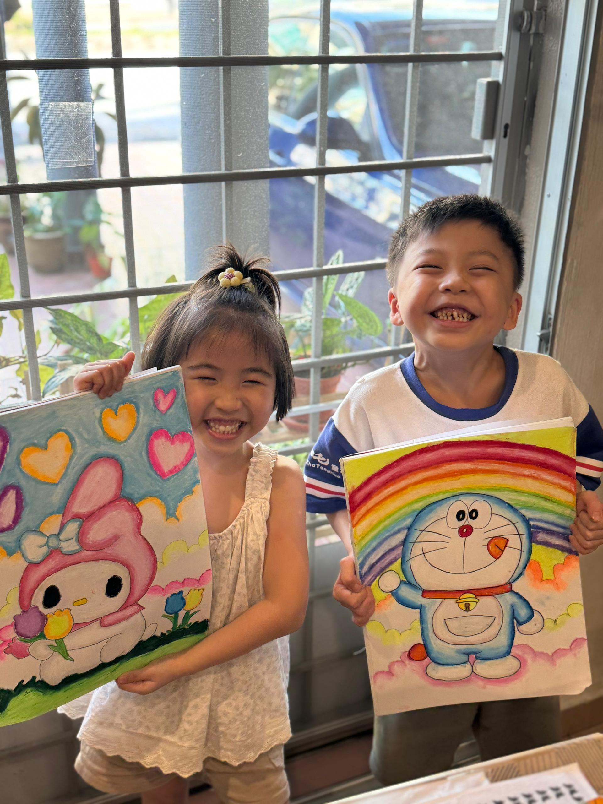 Children sharing artwork with bright smiles
